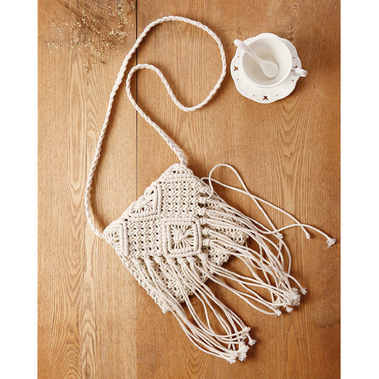 Macrame bag with fringes on a wooden surface