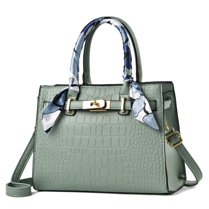 Light green croc-textured tote bag with blue patterned scarf handles
