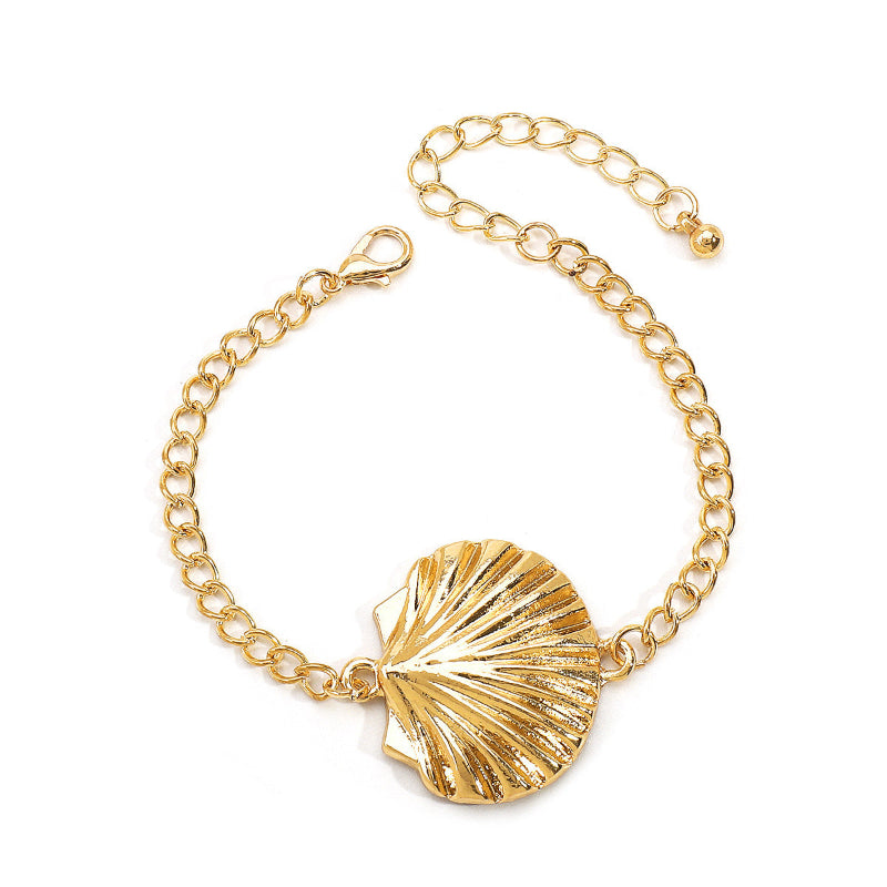Gold curb chain bracelet with scallop shell charm centerpiece