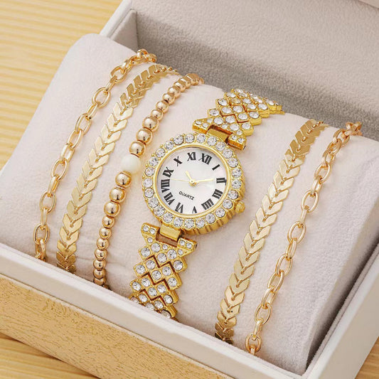 Gold watch and bracelets displayed in a jewelry box