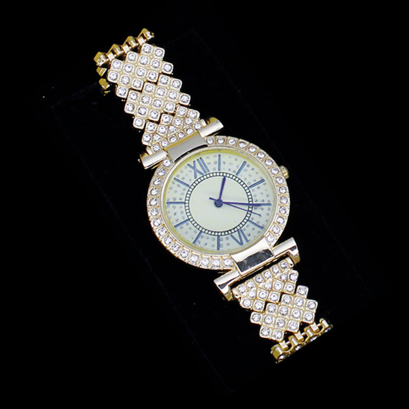 Rhinestone wristwatch with gold-tone case, pale dial, and jewel-studded link bracelet