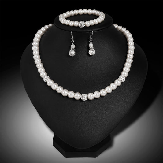 Pearl necklace, bracelet, and earrings set on a black stand