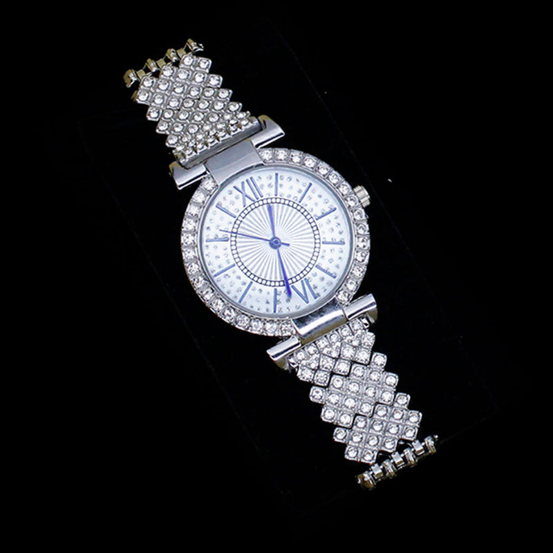 Rhinestone wristwatch with round crystal bezel, pale dial, and textured bracelet band