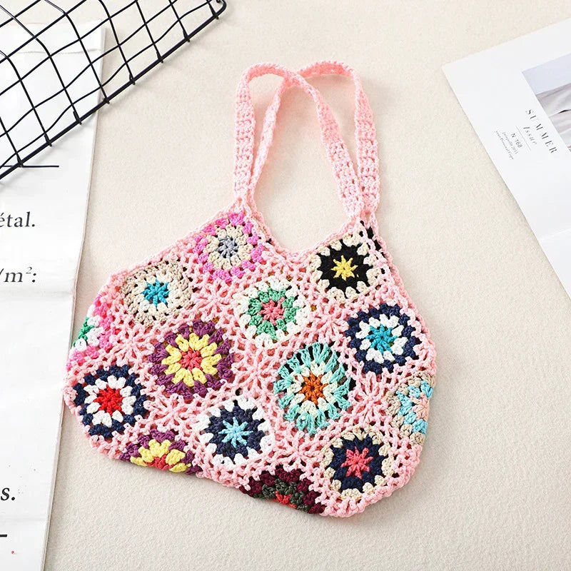 Handmade crochet wool handbag tote with pink base, multicolor floral granny squares, and loop handles.