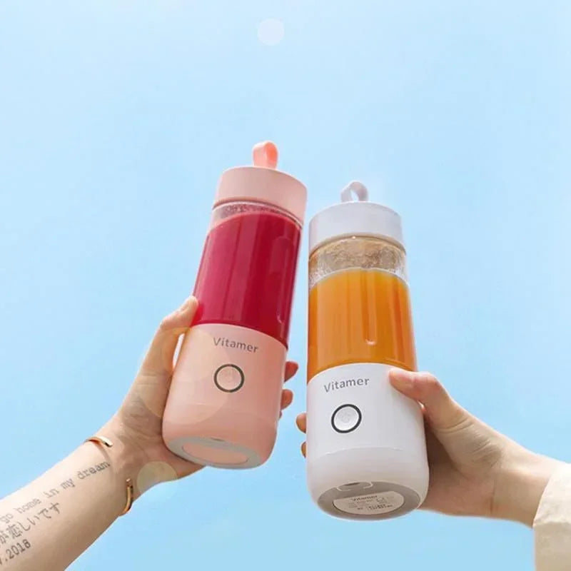 Pink and white portable blender bottles held up, each filled with red and orange drink