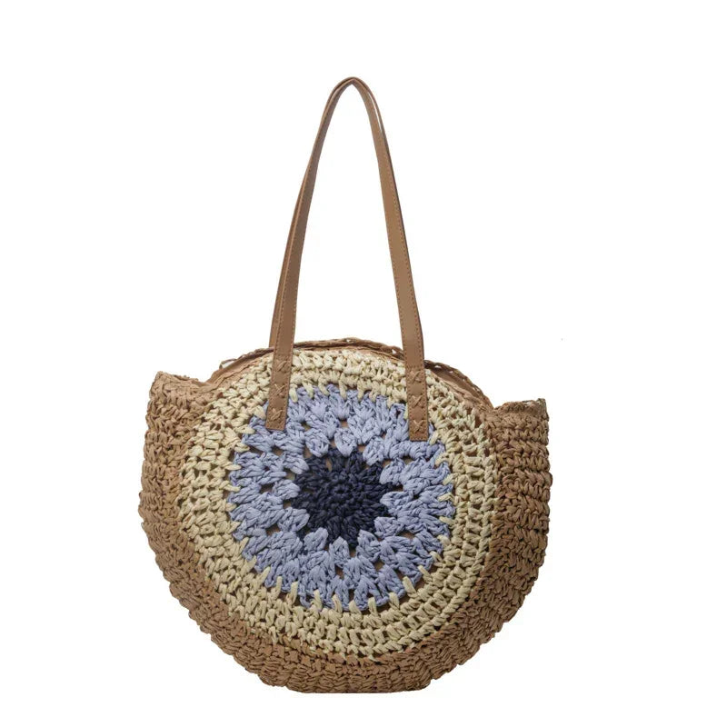 Crochet straw tote bag with light blue round floral center and brown leather handles