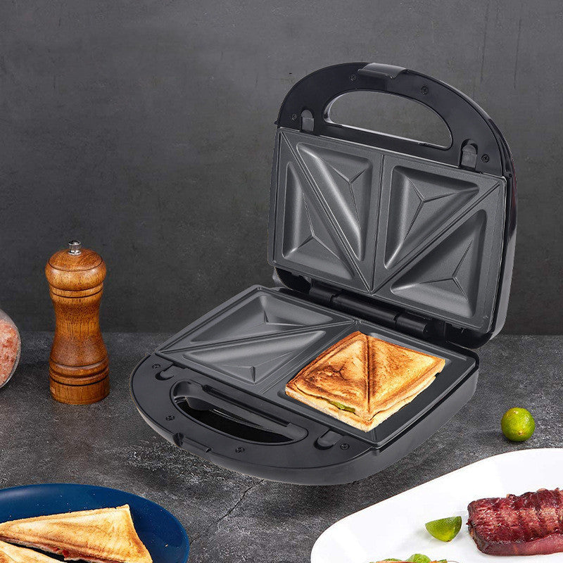 Black electric sandwich maker with open lid and toasted sandwich in plate