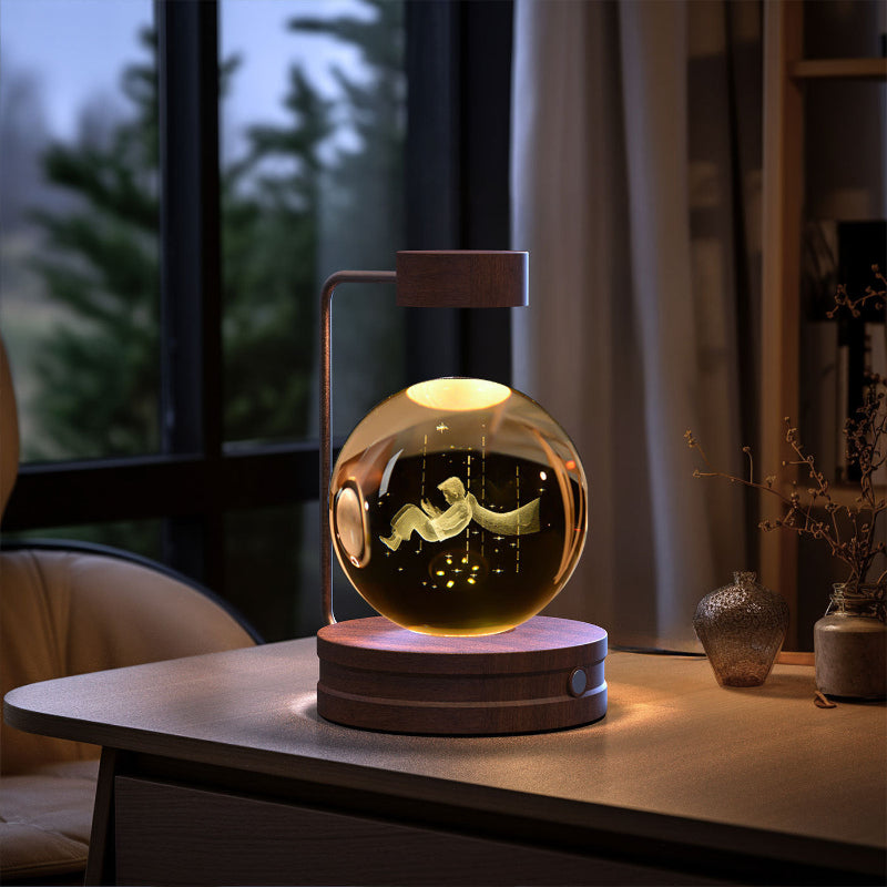 Glowing crystal-ball LED night light on round dark wood base with warm light and starry specks.