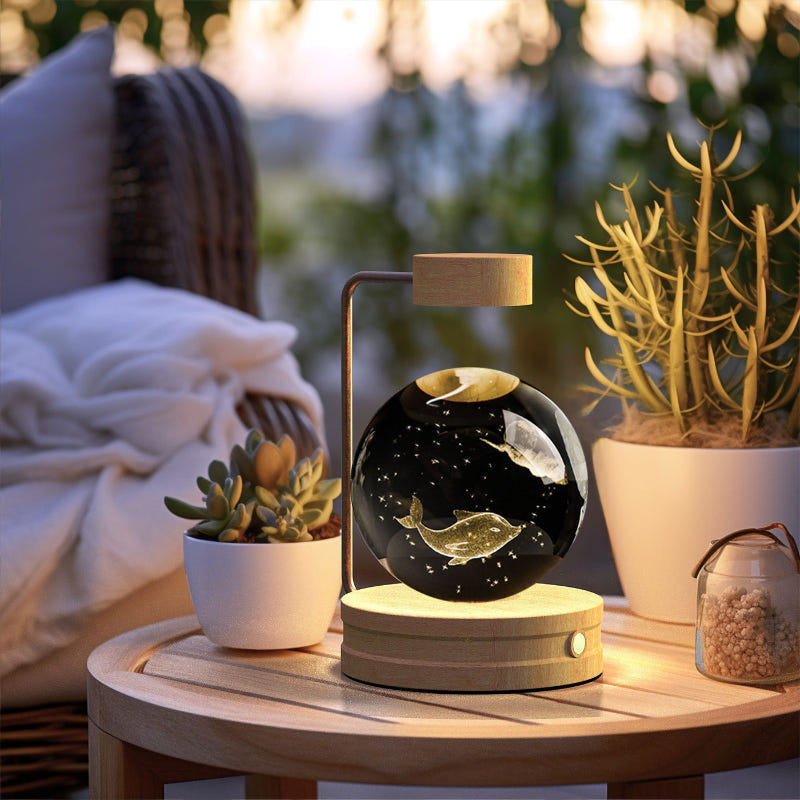 Crystal ball LED night light with dark glowing sphere inside clear glass dome and wood base