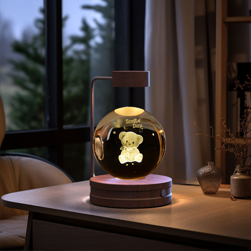 Crystal ball LED night light with smiling bear figure in clear globe, light wood base