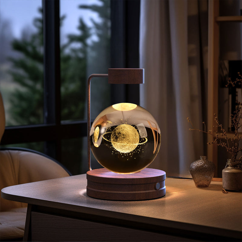 Glowing crystal-ball LED night light with warm light inside clear globe on round wooden base.
