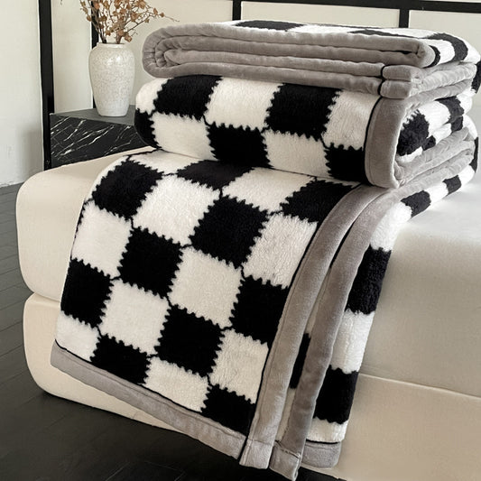 Black and white checkered blanket with gray border on a couch