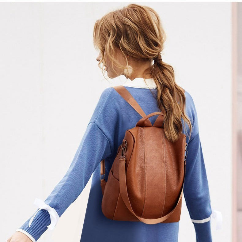 Brown PU leather backpack with adjustable straps and top handle, front flap and zippers