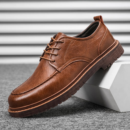 Brown leather shoe on a gray surface with a white background