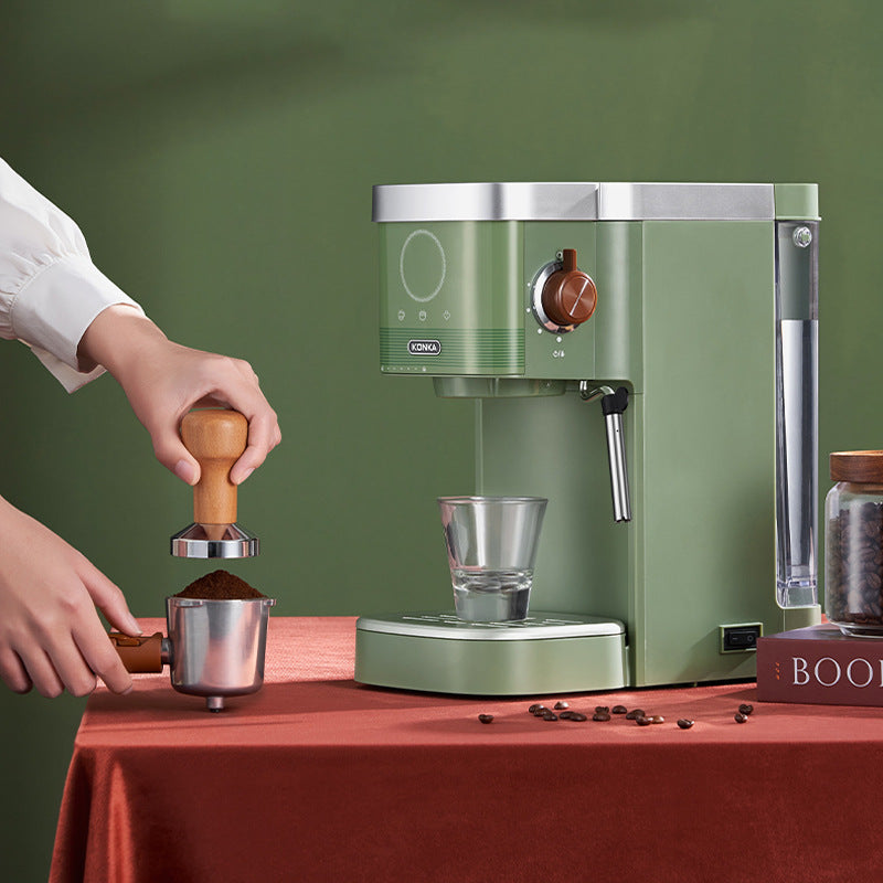 Green countertop insulated coffee maker with grinder area, clear cup, and side dispenser
