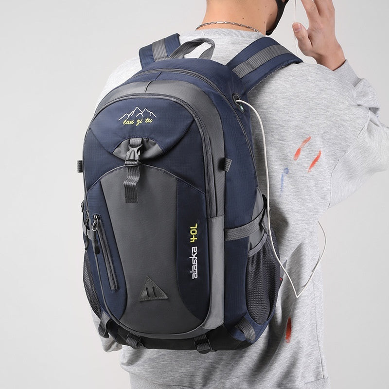 Outdoor polyester backpack in dark navy and gray with top handle and front compartments.