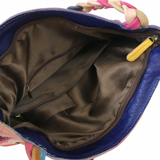 Close-up of a blue bag with a colorful handle, open to reveal a brown interior.
