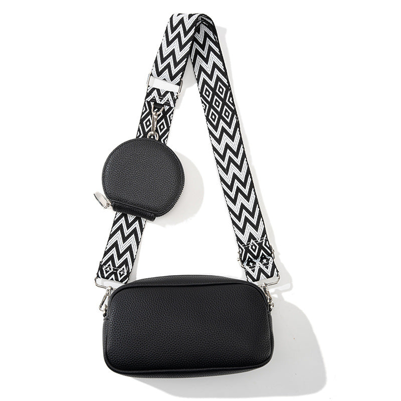 Women's casual crossbody bag in black with zip front and chevron patterned strap