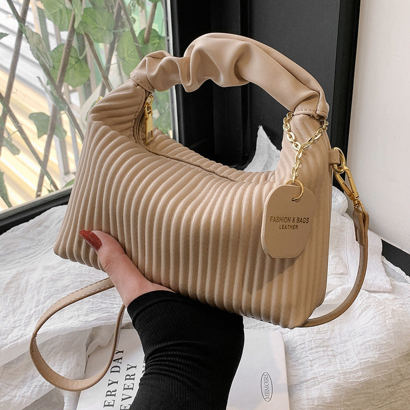 Beige ribbed PU leather hobo crossbody bag with gold chain strap and charm tag