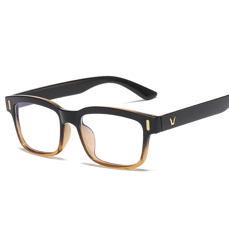 Small rectangular eyeglasses with black frame and clear lenses, gold accents.