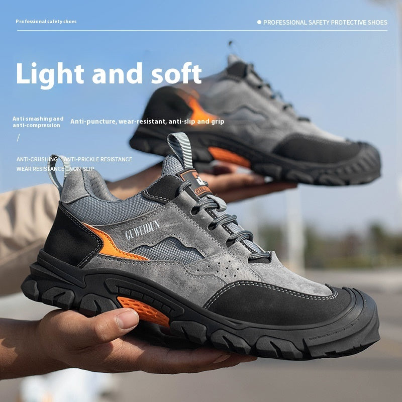 Men's grey and black safety shoes held in hand, orange outsole detail