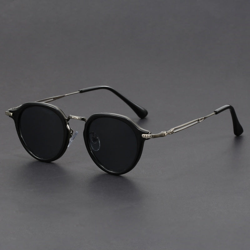 Unisex round metal sunglasses with black frames and dark lenses, side view