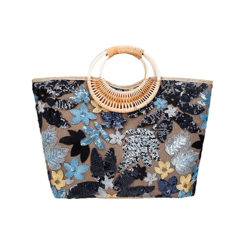 Large woven cotton tote bag with dark floral sequins and rattan half-moon top handle