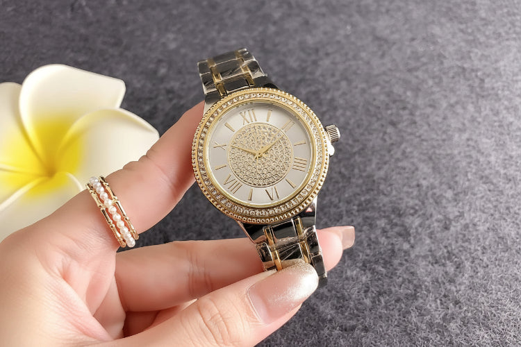 Gold bracelet watch with crystal-studded bezel and textured dial pattern