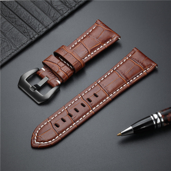 Brown leather watch strap with metal buckle, croc texture, and white stitching.