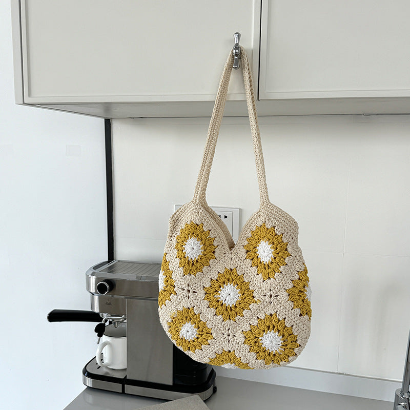 Crocheted bag with floral pattern hanging on a kitchen cabinet