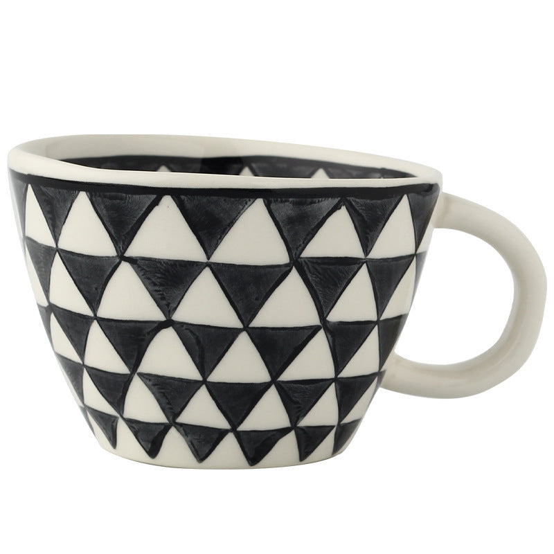 Ceramic mug with repeating black triangle pattern and white handle