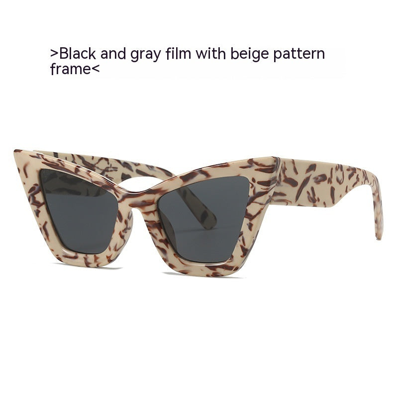 Beige patterned cat-eye sunglasses with dark lenses and black frame accents