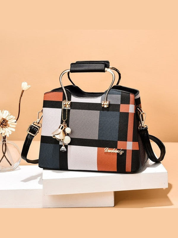 Plaid handbag with top handle, black crossbody strap, gold-tone hardware and charm dangle