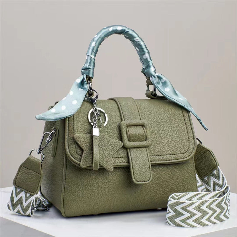 Olive green handbag with top flap, front buckle detail, and patterned chevron strap accents