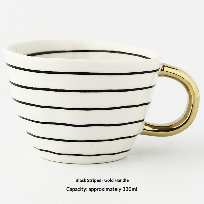 Ceramic mug with bold black horizontal stripes and gold handle