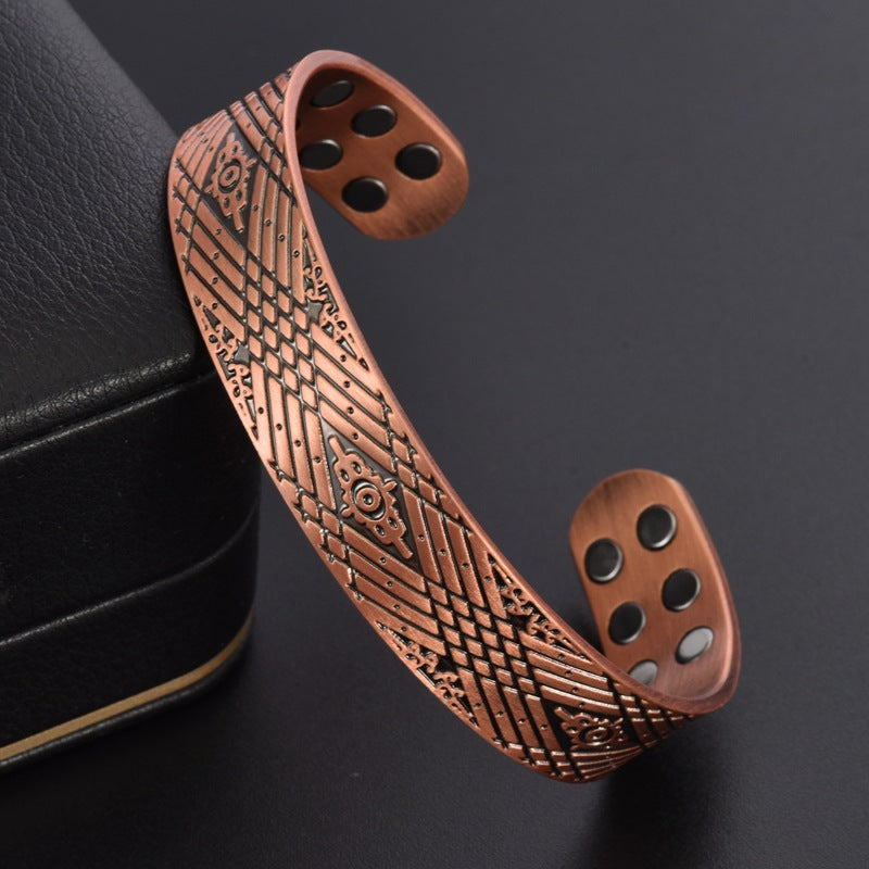 Copper-tone magnetic therapy bracelet with etched pattern band and round magnet inlays.
