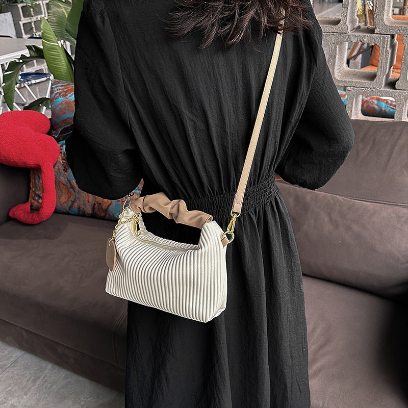 Black and beige striped ribbed PU leather crossbody bag with chain strap and charm tag