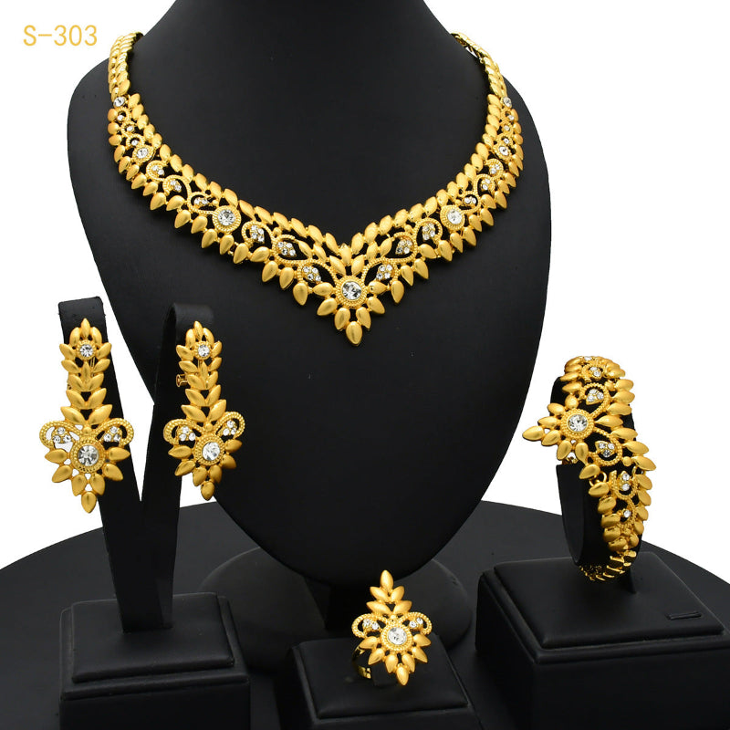 Gold-tone four-piece jewelry set with leaf-fringe necklace, matching bracelet, earrings, and ring