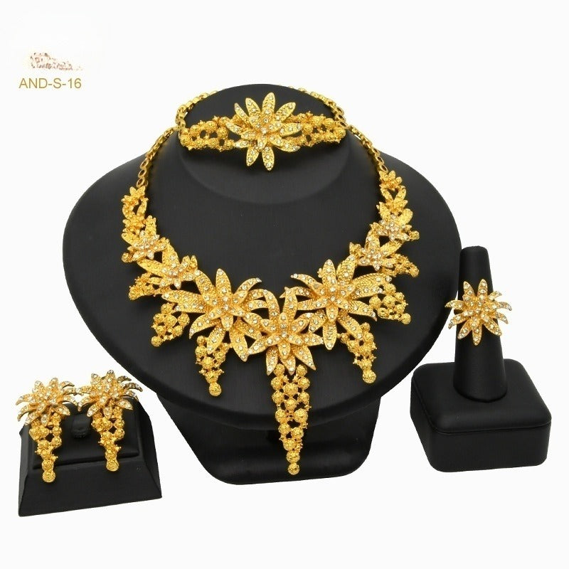 Gold-plated floral jewelry set with necklace, bracelet, stud earrings, and ring