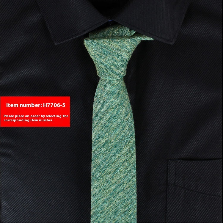 Narrow cotton tie in teal green textured weave, slim knot.