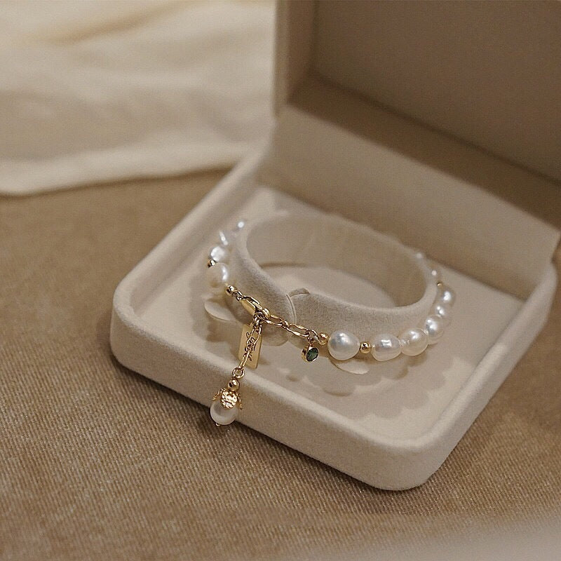 Gold pearl charm bracelet with green zircon and pearl tassel in box