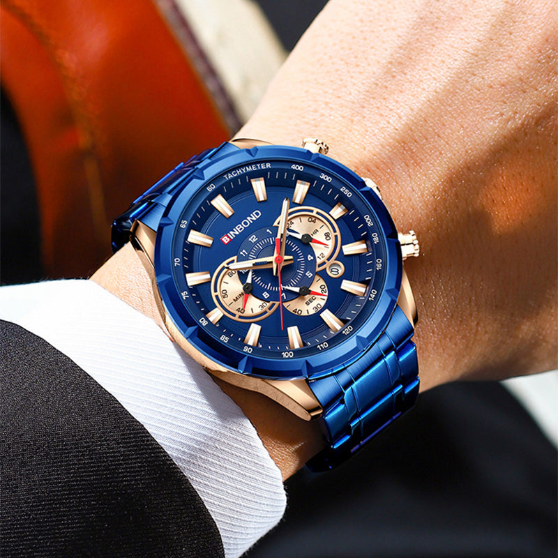 Blue multi-function tactical wristwatch on wrist with gold bezel and blue metal band
