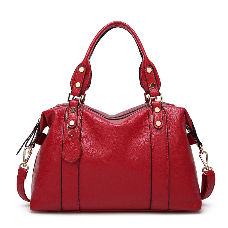 Red PU leather tote handbag with twin top handles and side shoulder strap hardware