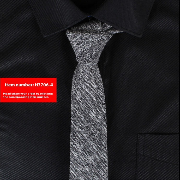 Narrow cotton tie in dark gray textured fabric, slim knot.