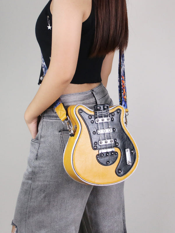 Guitar-shaped crossbody bag with yellow front, black hardware, and patterned strap
