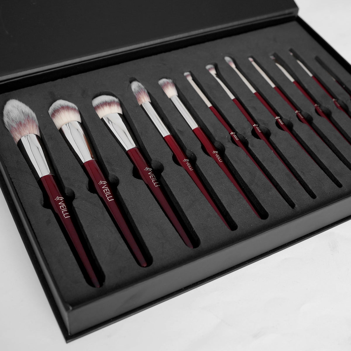 Twelve makeup brushes arranged in a fitted black case