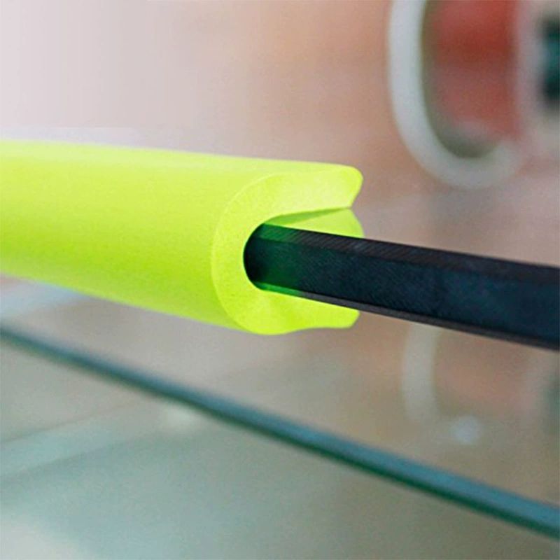 Bright green foam edge guard fitted over a dark table edge