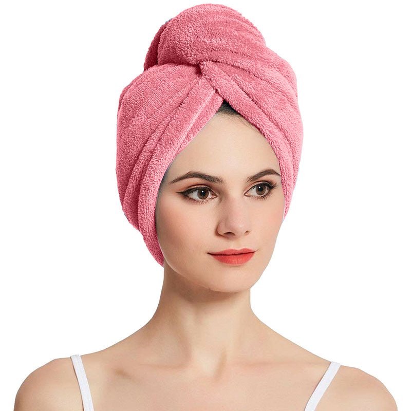 Pink hair drying cap towel wrapped around the head with a twisted front.