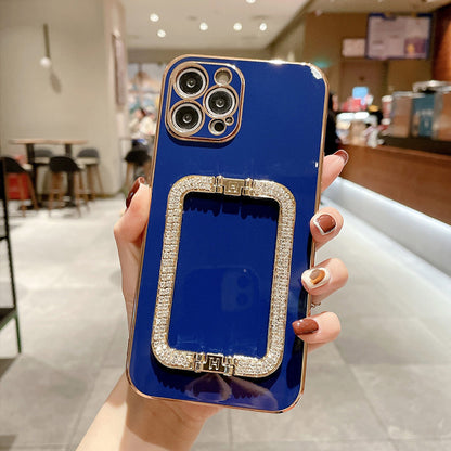 Blue phone case with diamond accents held by a hand in an indoor setting