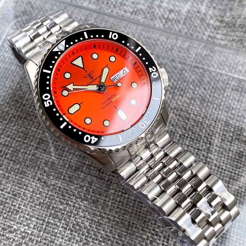 Watch with a red face and silver metal strap on a textured gray background